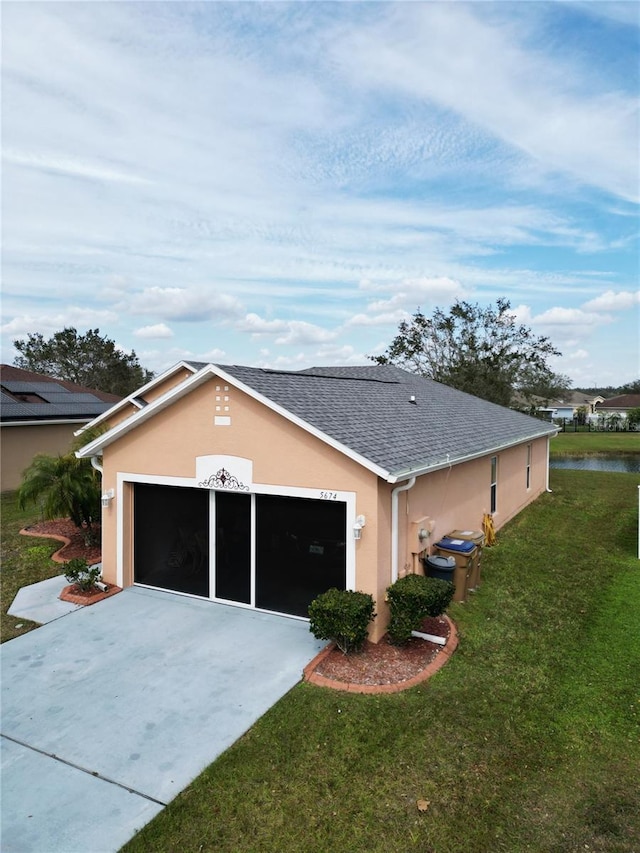 view of side of property featuring a garage and a yard