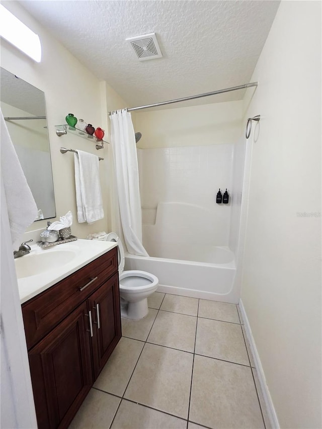 full bathroom with vanity, a textured ceiling, tile patterned floors, toilet, and shower / bath combo with shower curtain