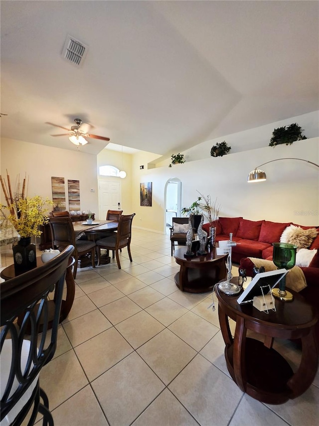 living room featuring vaulted ceiling, light tile patterned floors, and ceiling fan