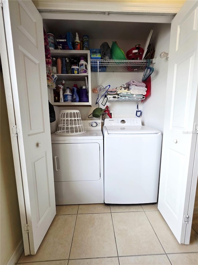 clothes washing area featuring washer and dryer and light tile patterned floors