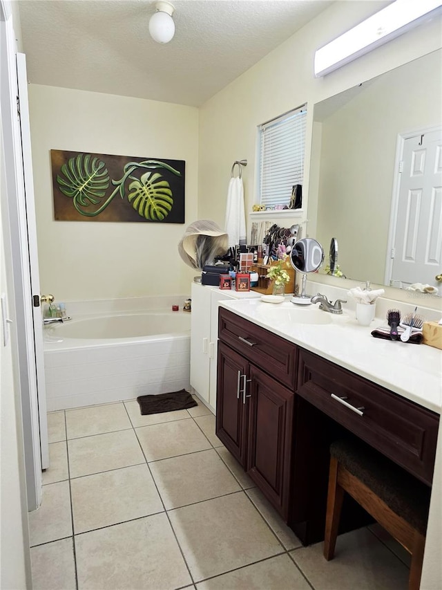 bathroom featuring tile patterned flooring, vanity, a tub, and a textured ceiling