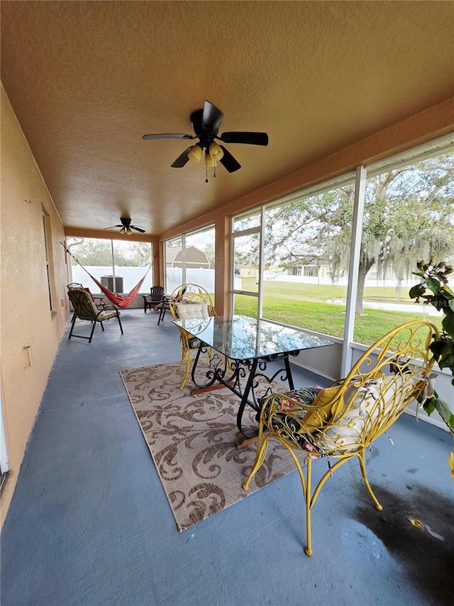 sunroom featuring ceiling fan and plenty of natural light