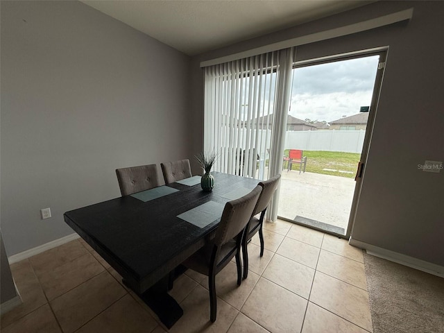 dining space featuring light tile patterned flooring and baseboards