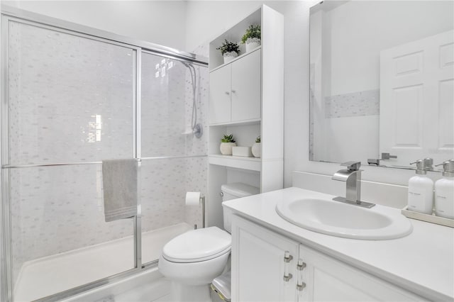 bathroom featuring vanity, toilet, and an enclosed shower