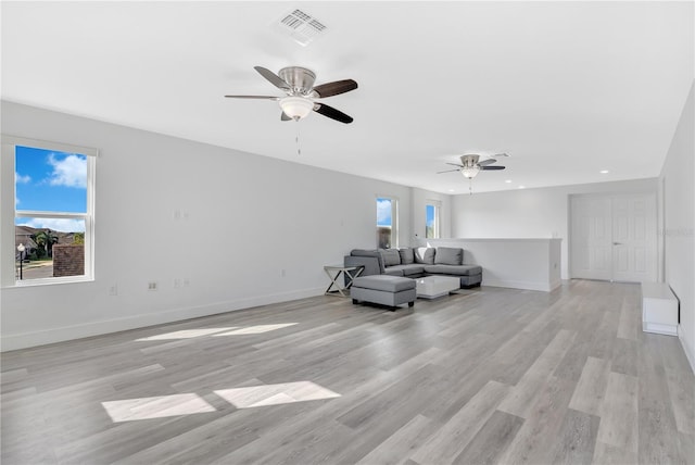 unfurnished living room featuring ceiling fan, plenty of natural light, and light hardwood / wood-style flooring