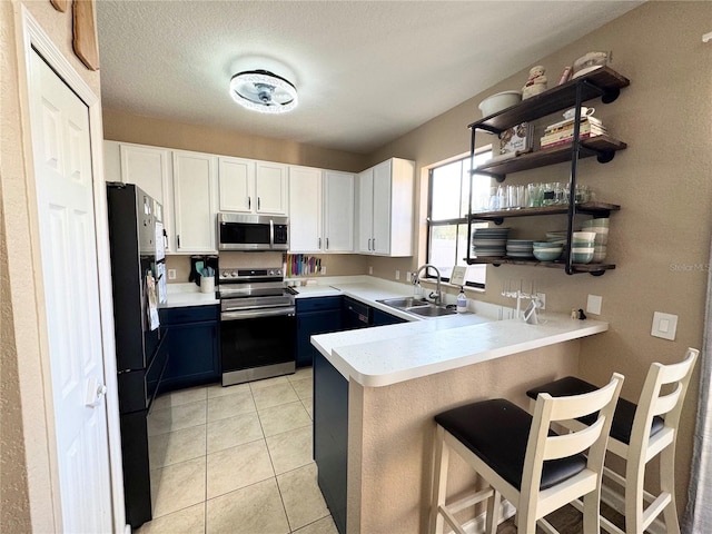 kitchen with sink, a breakfast bar area, white cabinetry, kitchen peninsula, and stainless steel appliances