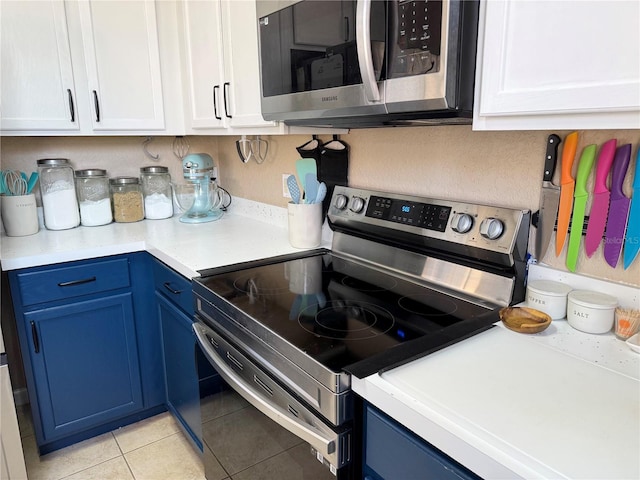 kitchen with white cabinetry, appliances with stainless steel finishes, and blue cabinetry