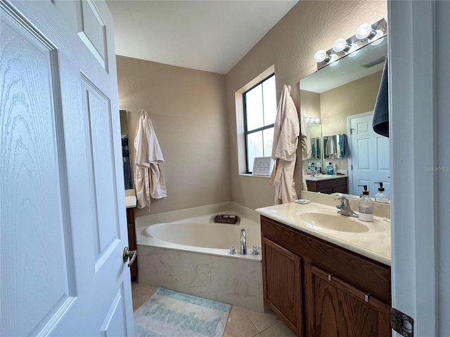 bathroom with tile patterned floors, a bathtub, and vanity