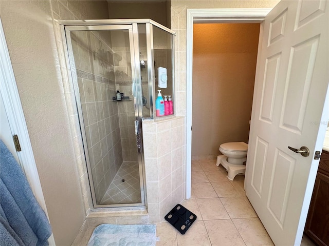 bathroom with an enclosed shower, vanity, tile patterned floors, and toilet