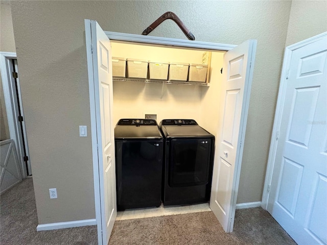 laundry area featuring washing machine and dryer and light carpet