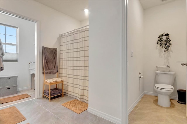 bathroom featuring a shower with curtain, tile patterned floors, and toilet