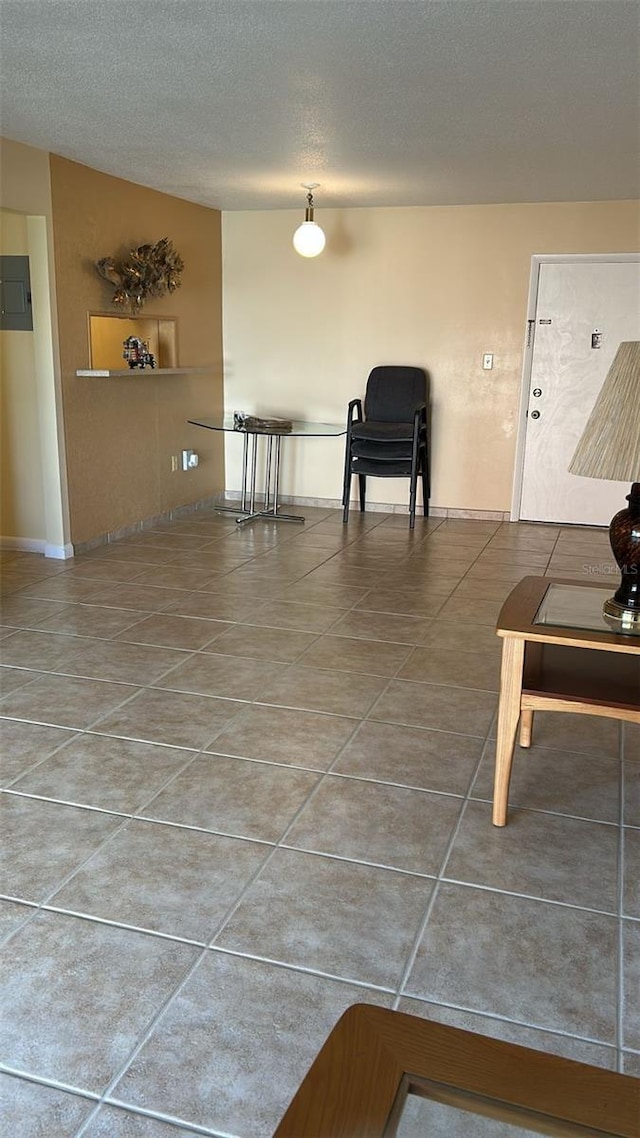 living room with tile patterned flooring, electric panel, and a textured ceiling