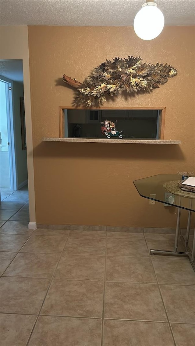 interior space featuring tile patterned flooring and a textured ceiling