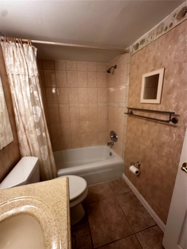 full bathroom featuring sink, a textured ceiling, toilet, tile patterned floors, and shower / tub combo with curtain