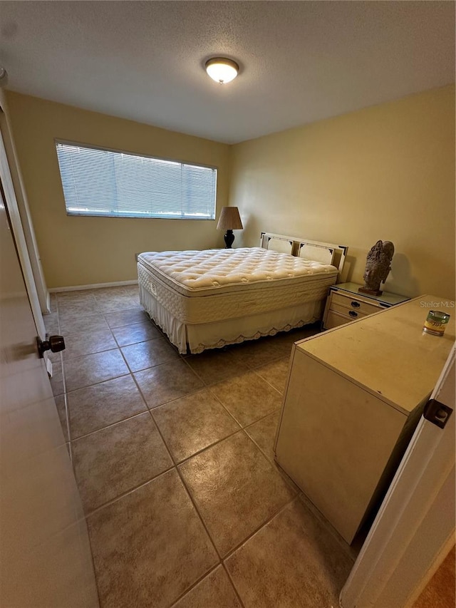 bedroom featuring light tile patterned flooring and a textured ceiling