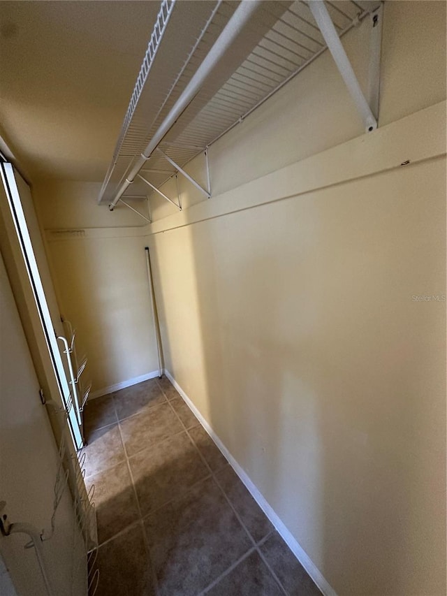 walk in closet featuring dark tile patterned flooring