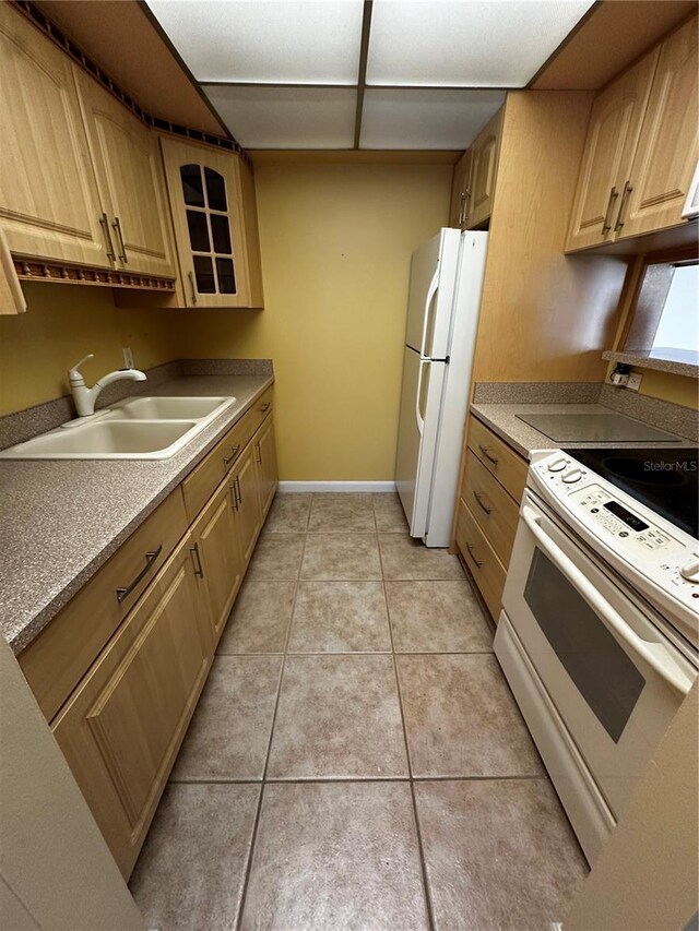 kitchen featuring sink, light brown cabinetry, white appliances, and light tile patterned flooring