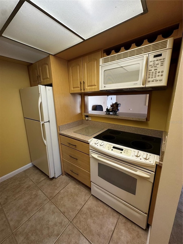 kitchen with white appliances, light tile patterned flooring, and light brown cabinetry