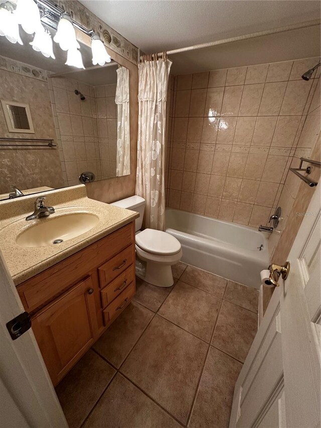 full bathroom with tile patterned floors, toilet, shower / bath combination with curtain, and vanity