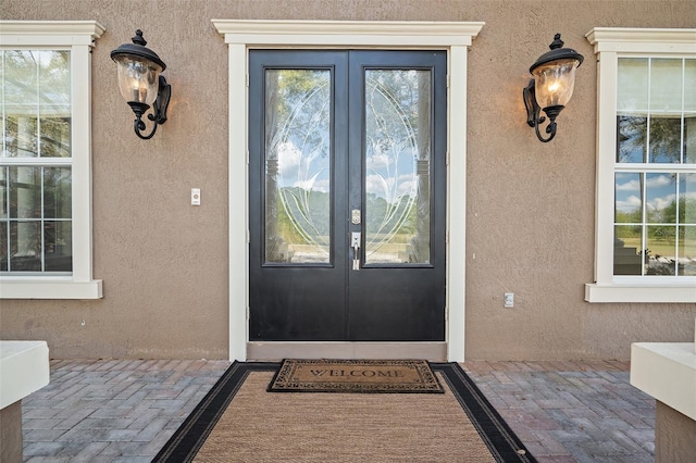 entrance to property featuring stucco siding and french doors