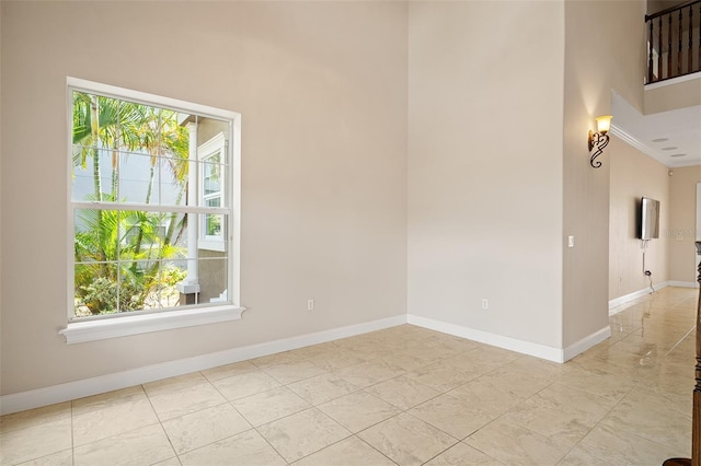 unfurnished room with crown molding and baseboards