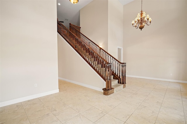 stairs featuring a high ceiling, a notable chandelier, and baseboards