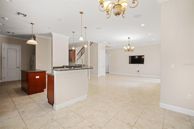 kitchen featuring dark countertops, visible vents, a notable chandelier, and ornamental molding