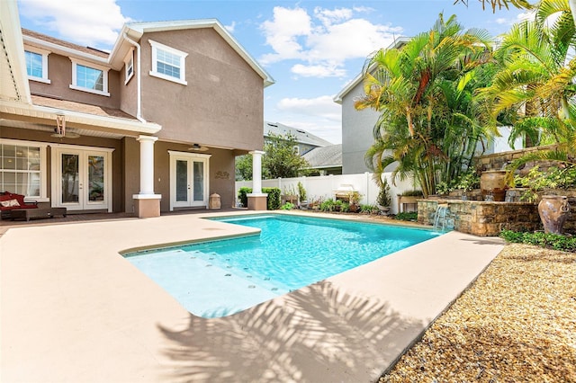 view of swimming pool featuring a patio, a fenced backyard, a ceiling fan, french doors, and a fenced in pool