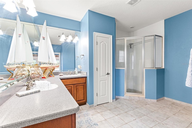 full bath featuring a textured ceiling, vanity, a shower stall, and visible vents