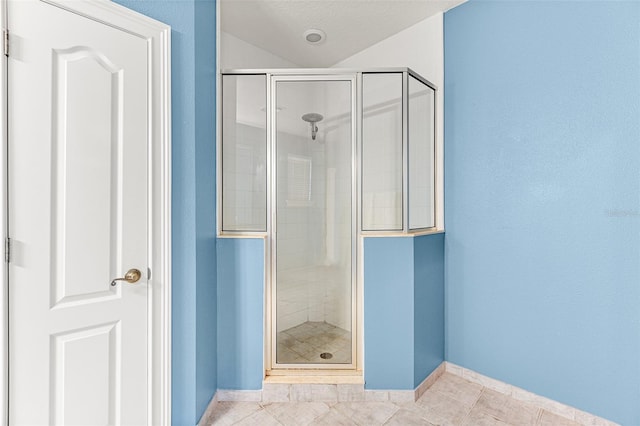 bathroom featuring a shower stall, baseboards, and tile patterned floors