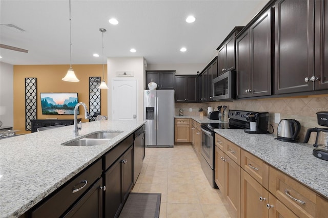 kitchen with sink, decorative backsplash, light stone countertops, and appliances with stainless steel finishes