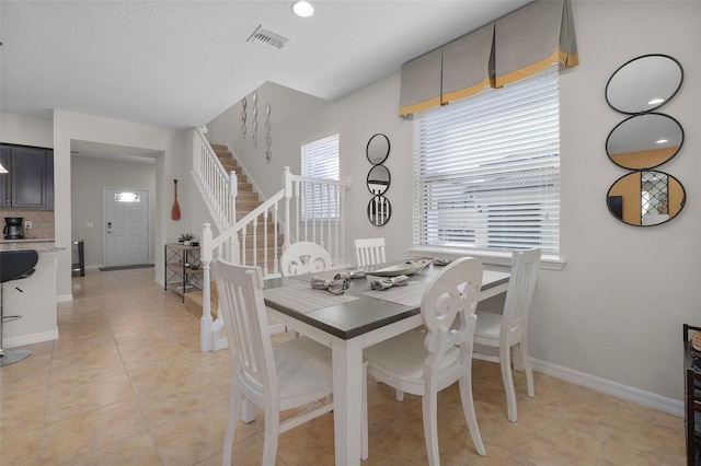 tiled dining area featuring a textured ceiling