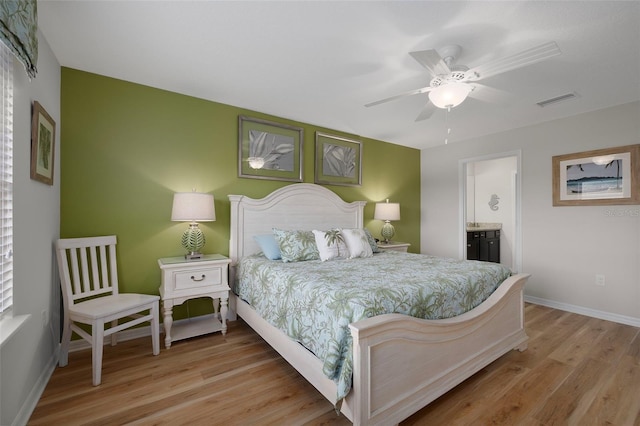 bedroom featuring ceiling fan, connected bathroom, and light hardwood / wood-style floors