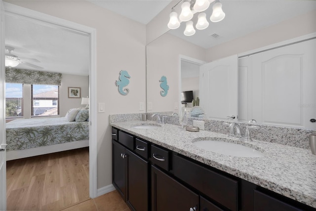 bathroom with hardwood / wood-style floors, vanity, and ceiling fan with notable chandelier