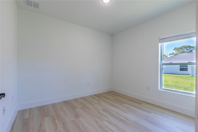 unfurnished room with baseboards, plenty of natural light, visible vents, and light wood-style floors