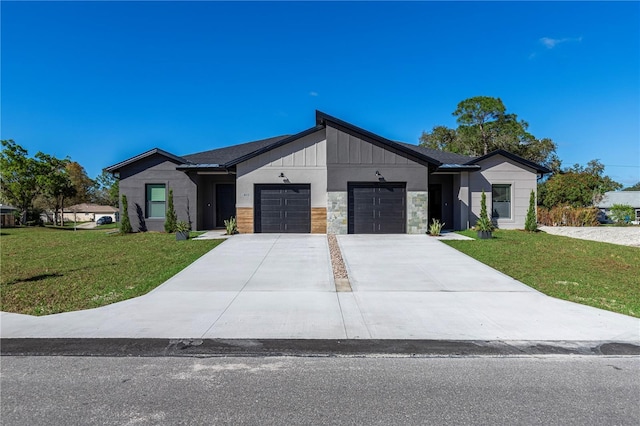 view of front of property featuring a garage, driveway, stone siding, board and batten siding, and a front yard