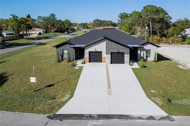 modern farmhouse featuring roof with shingles, a front yard, a garage, stone siding, and driveway