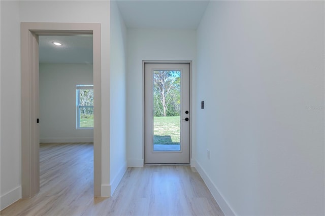 doorway to outside with light wood-style flooring and baseboards