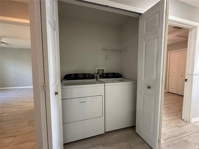 clothes washing area featuring light tile patterned flooring, separate washer and dryer, and ceiling fan