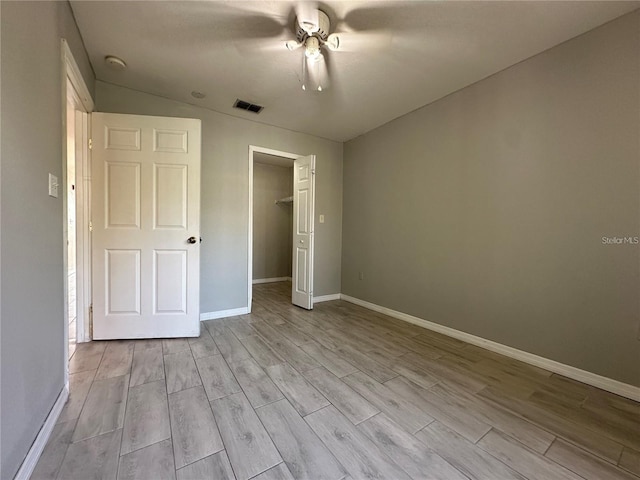 unfurnished bedroom featuring ceiling fan, a closet, and light hardwood / wood-style flooring