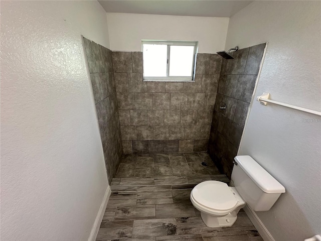 bathroom with toilet and a tile shower