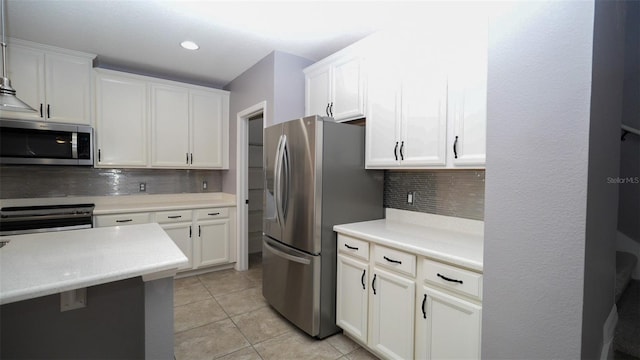 kitchen with tasteful backsplash, light countertops, light tile patterned flooring, white cabinets, and stainless steel appliances