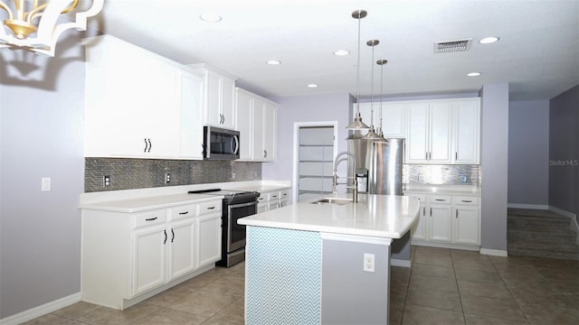 kitchen featuring visible vents, stainless steel appliances, light countertops, and a sink