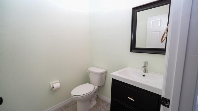 bathroom featuring baseboards, toilet, vanity, and tile patterned flooring