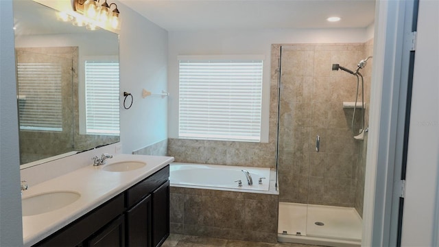 bathroom with a bath, tiled shower, a wealth of natural light, and a sink