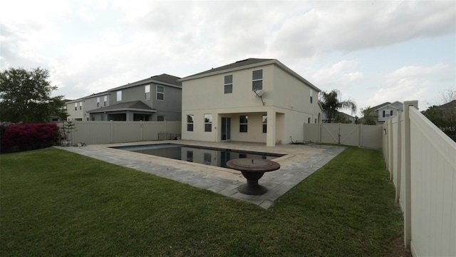 back of house featuring a gate, a fenced in pool, a yard, a fenced backyard, and a patio area