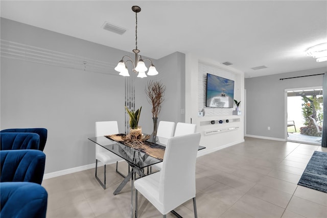 tiled dining room with an inviting chandelier