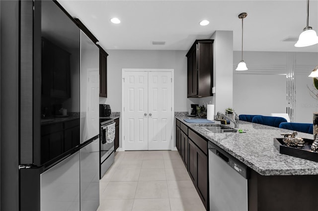 kitchen featuring light tile patterned flooring, appliances with stainless steel finishes, decorative light fixtures, sink, and dark brown cabinets