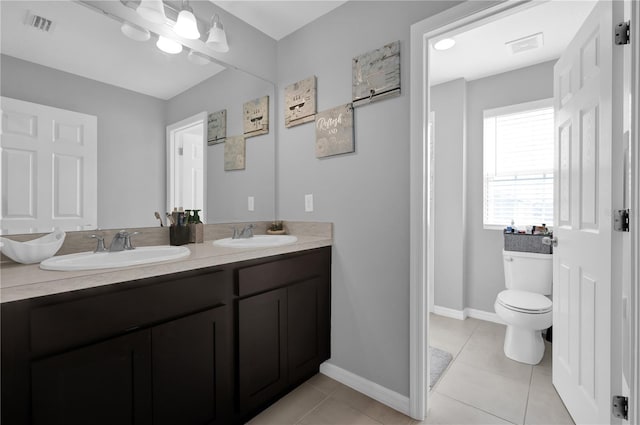 bathroom with vanity, toilet, and tile patterned flooring