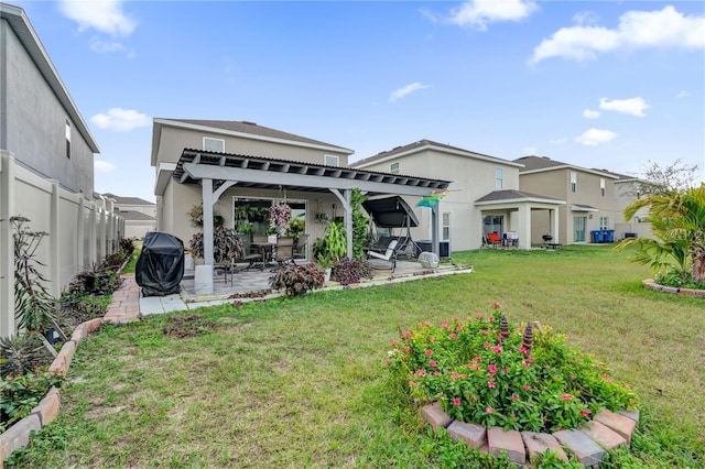 rear view of property with a pergola, a lawn, and a patio area